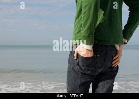 Junge Mann stand am Strand Betrachtung Ansicht beschnitten Stockfoto