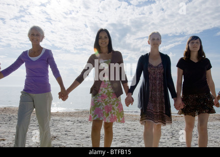 Gruppe von Menschen Hand in Hand, zu Fuß am Strand Stockfoto