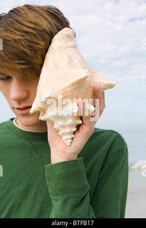 Junge Männchen Muschelschale anhören Stockfoto