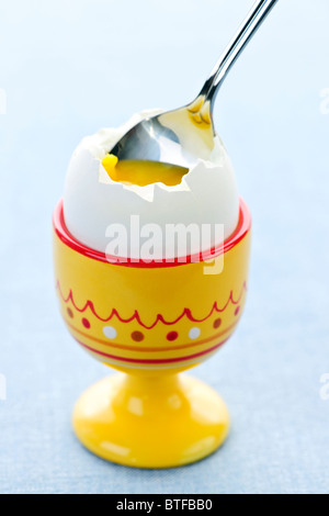 Nahaufnahme von weich gekochtes Ei in eine Tasse mit Löffel Stockfoto