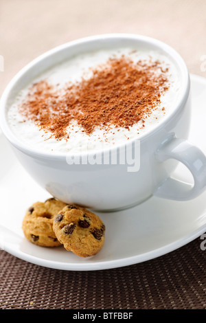 Cappuccino oder Latte, die in Tasse mit Milchschaum und Cookies Kaffee Stockfoto