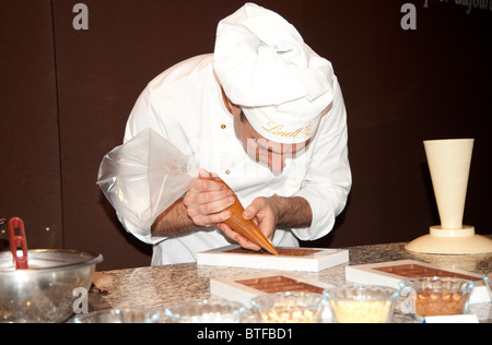 Ein Koch gießt Schokolade in die Fächer Lindt Schokolade zu machen, "Salon du Chocolat", Paris, Frankreich Stockfoto