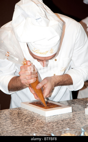 Ein Koch gießt Schokolade in die Fächer Lindt Schokolade zu machen, "Salon du Chocolat", Paris, Frankreich Stockfoto