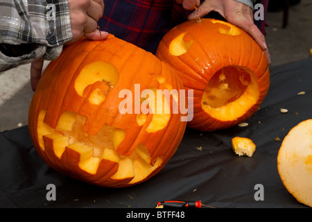 Zwei jungen schnitzen Kürbisse in Jack-o-Laternen während der Keene Halloween Kürbis-Festival in New Hampshire. Stockfoto