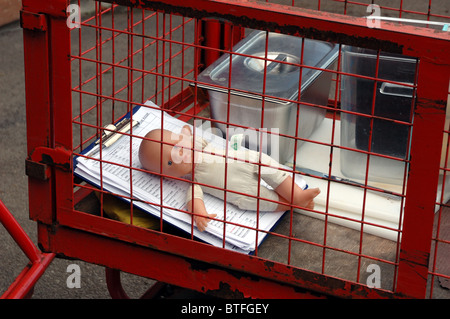 Verlassene Puppe im roten Wagen Stockfoto