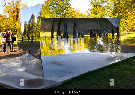 Besucher der Kensington Gardens, die sich in den Herbstfarben der Anish Kapoor Sky Mirrors C Curve London, England, wiederspiegeln Stockfoto