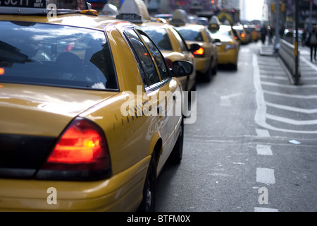 lange Reihe von gelben Taxis in der Warteschlange in der Nähe von Times Square mit Bremsleuchten auf Stockfoto