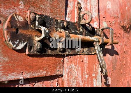 Nahaufnahme von rostigen alten Türriegel am Scheunentor mit abblätternde Farbe. Stockfoto