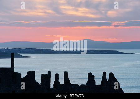 Dunluce Castle, County Antrim, Ulster, Nordirland, Vereinigtes Königreich. Silhouette von Ruinen bei Sonnenuntergang. Stockfoto