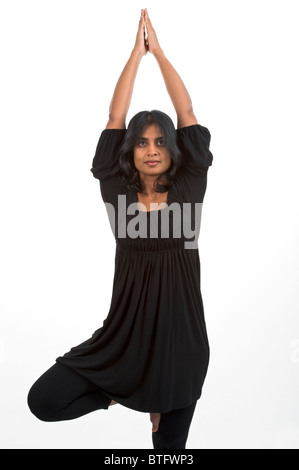 Frau von indischer Abstammung hält eine Yoga-Pose auf weißem Hintergrund Stockfoto