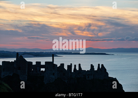 Dunluce Castle, County Antrim, Ulster, Nordirland, Vereinigtes Königreich. Silhouette von Ruinen bei Sonnenuntergang. Stockfoto