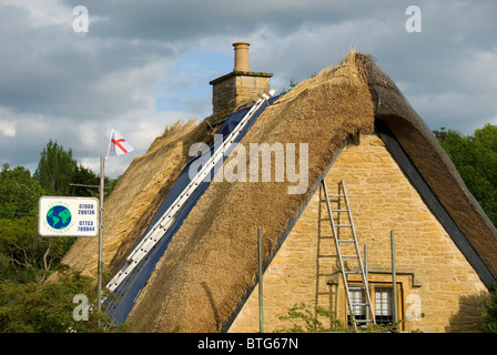 Reetgedeckte Haus Dach repariert bekommen, Cotswolds, England, UK Stockfoto