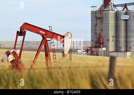 Prairie Weizenfeld, Ölquelle Pumpe Jack und im Landesinneren Getreideterminal.  Gull Lake, Saskatchewan, Kanada. Stockfoto