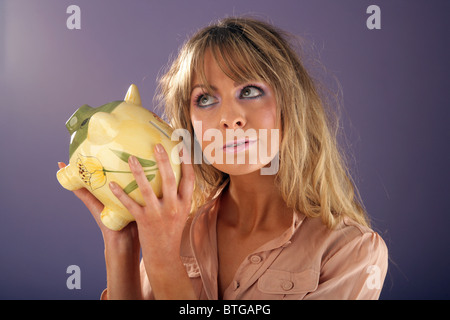Frau hält ein Sparschwein. Stockfoto