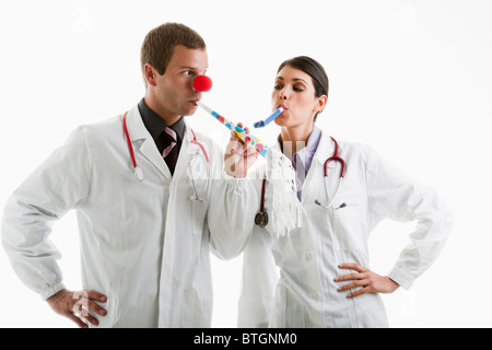 Männliche und weibliche Ärzte mit Party Spielzeug Stockfoto