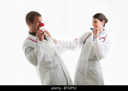 Männliche und weibliche Ärzte mit Party Spielzeug Stockfoto