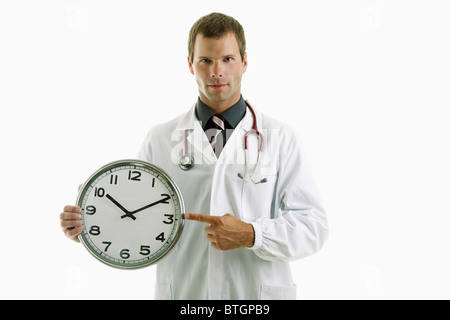 Arzt Holding-Uhr zeigt Zeit Stockfoto