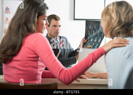 Frau tröstet Patienten beim Arztbesuch Stockfoto