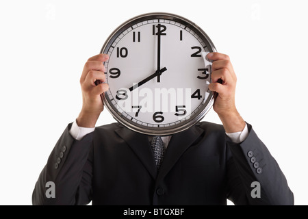 Mann-Betrieb-Uhr vor seinem Gesicht Stockfoto