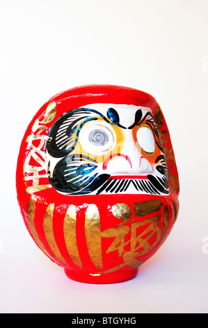 Einen roten und weißen Daruma-Kopf, mit einem Auge auf einem weißen Hintergrund gemalt. Stockfoto