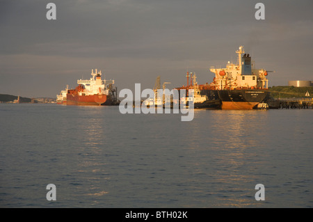 Schlepper drücken Öltanker auf Steg, Texaco oil Raffinerie, Milford Haven, Pembrokeshire, Wales, UK, Europa Stockfoto