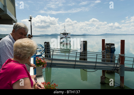 warten auf die Fähre an der Bootsanlegestelle in Passignano Sul Trasimeno am Lago Trasimeno in Umbrien Region von Italien. Das Boot von hier nimmt Touristen nach Tuoro Sul Trasimeno und Isola Maggiore. Stockfoto