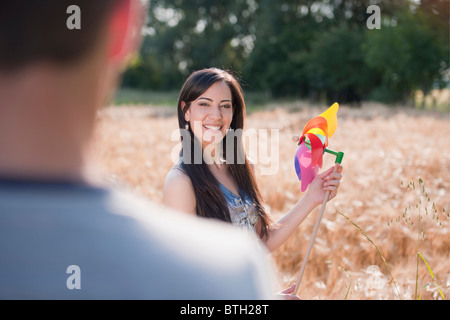 Junge Frau mit Mann, hält Windrad im Weizenfeld Stockfoto