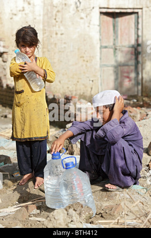 Ein Mädchen mit einer Flasche Wasser auf dem Arm, Nowshera, Pakistan Stockfoto