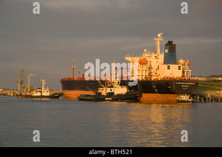 Schlepper drücken Öltanker auf Steg, Texaco oil Raffinerie, Milford Haven, Pembrokeshire, Wales, UK, Europa Stockfoto