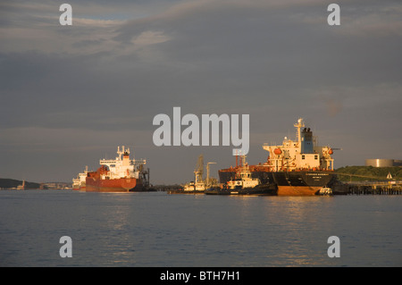 Schlepper drücken Öltanker auf Steg, Texaco oil Raffinerie, Milford Haven, Pembrokeshire, Wales, UK, Europa Stockfoto