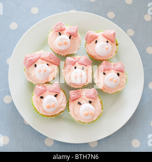 Ein Teller mit rosa Schwein iced hausgemachten Brötchen für eine Kinder-Geburtstags-party Stockfoto