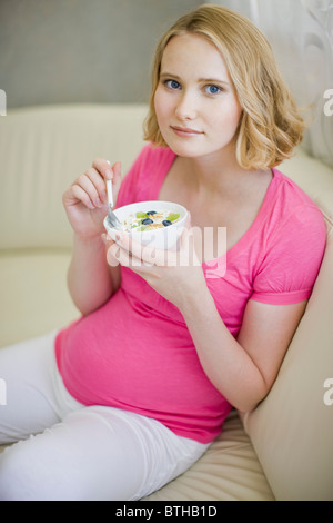 Schwangere Frau essen Müsli Stockfoto