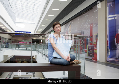Junge Frau sitzt im neuen Einkaufszentrum Voronezh Stockfoto