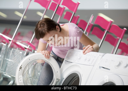 Junge Frau wählt Waschmaschine im Einkaufszentrum, Voronezh Stockfoto