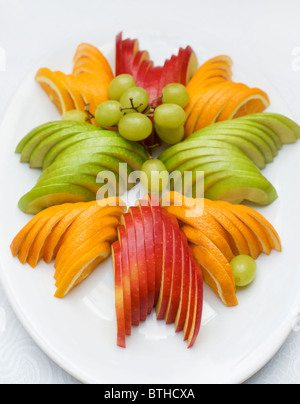 in Scheiben geschnittenen Äpfel und Orangen mit Trauben auf ovalen Platte, flachen DOF, Fokus auf dem vorderen Apfel Stockfoto