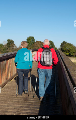 Zwei mittleren Alters Wanderer mit Wanderstöcken gehen über eine Holzbrücke über die Jubilee Rive. Stockfoto