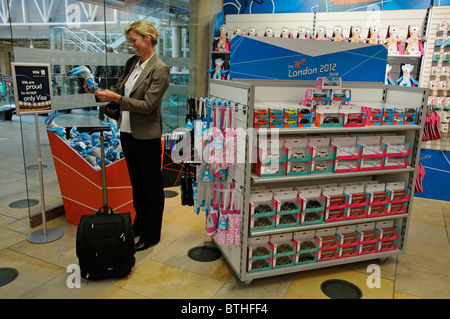 2012 Olympische Spiele shop eröffnet. Frau, die Auswahl einer London 2012 Olympische Spiele Wenlock-Maskottchen im neuen Shop an der Paddington Station UK Stockfoto