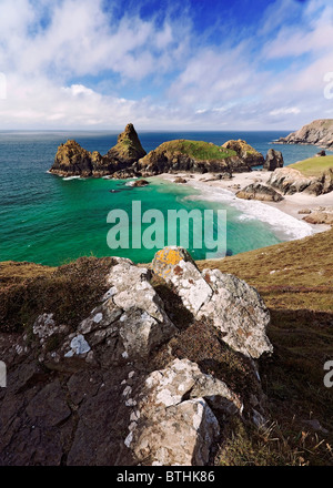 Ein Vordergrund Fels bietet Vordergrund für eine Ansicht über die atemberaubenden Farben der Kynance Cove, The Lizard Halbinsel Cornwall. Stockfoto