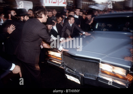 Trauernde zugehen, berühren Sie den Leichenwagen bei der Beerdigung von Rabbi Meir Kahane in Brooklyn in New York Stockfoto