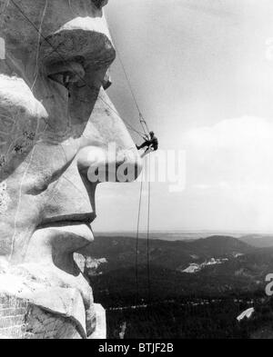 Eine Wartung Worker auf die Nase des Mount Rushmore Abraham Lincoln, South Dakota, c. der 1960er Jahre. Stockfoto