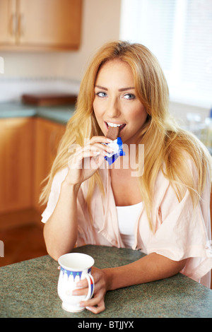 Mädchen in der Küche essen Schokolade Keks Stockfoto