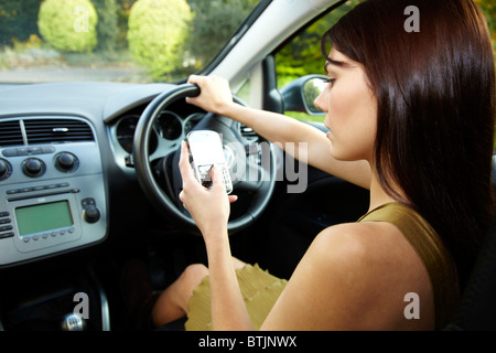 Frau fahren und mit Handy Stockfoto