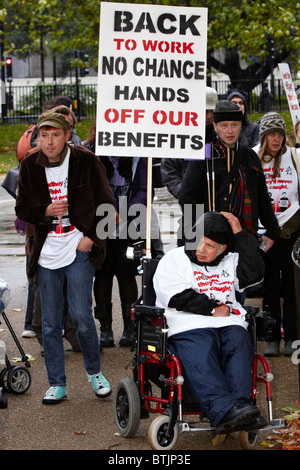 LONDON, VEREINIGTES KÖNIGREICH. Demonstranten, in einem Rollstuhl, halten Plakate während einer "Mad Pride" Kundgebung gegen Sozialabbau. Stockfoto