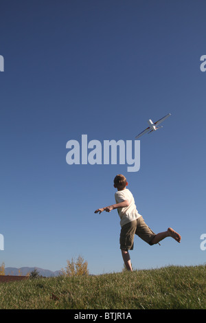 kleiner Junge werfen Spielzeugflugzeug in den Himmel Stockfoto