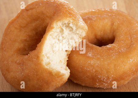 einfach nur Zucker leicht beschichtete Donuts bekannt als Soße Ringe mit Biss herausgenommen Stockfoto