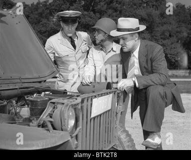 Zweiter Weltkrieg, steht George Woolslayer (rechts) untersucht einen Armee-Jeep bei der Post, wo Sergeant French L. Vineyard (Mitte) stationiert ist, Luftfahrt-Radio Chief John Marshall Evans auf der linken Seite, Allegheny Ludlum Steel, Pittsburgh, Pennsylvania, Foto von Alfred T. Palmer, August 1942 Stockfoto