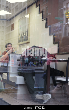 Ein Mann schläft in einem Fast-Food-Restaurant, New York City, USA Stockfoto