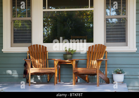 Zwei Adirondack Stühle auf einer Veranda mit Panoramafenster Hintergrund Stockfoto