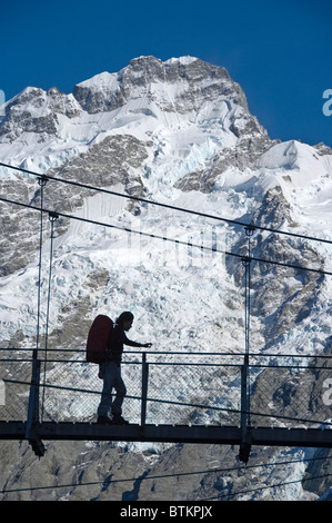 Neuseeland Südinsel Aoraki Mount Cook NP, Hooker Valley Trail, Wanderer auf erste Drehbrücke, Mt Sefton hinter Stockfoto