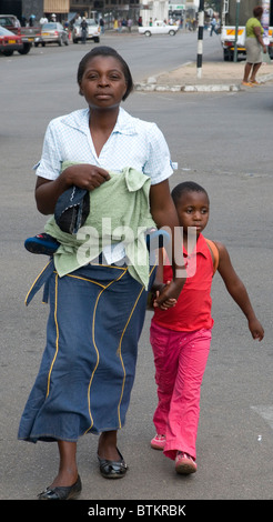 Frau und Kinder überqueren einer Straße in Bulawayo Stockfoto